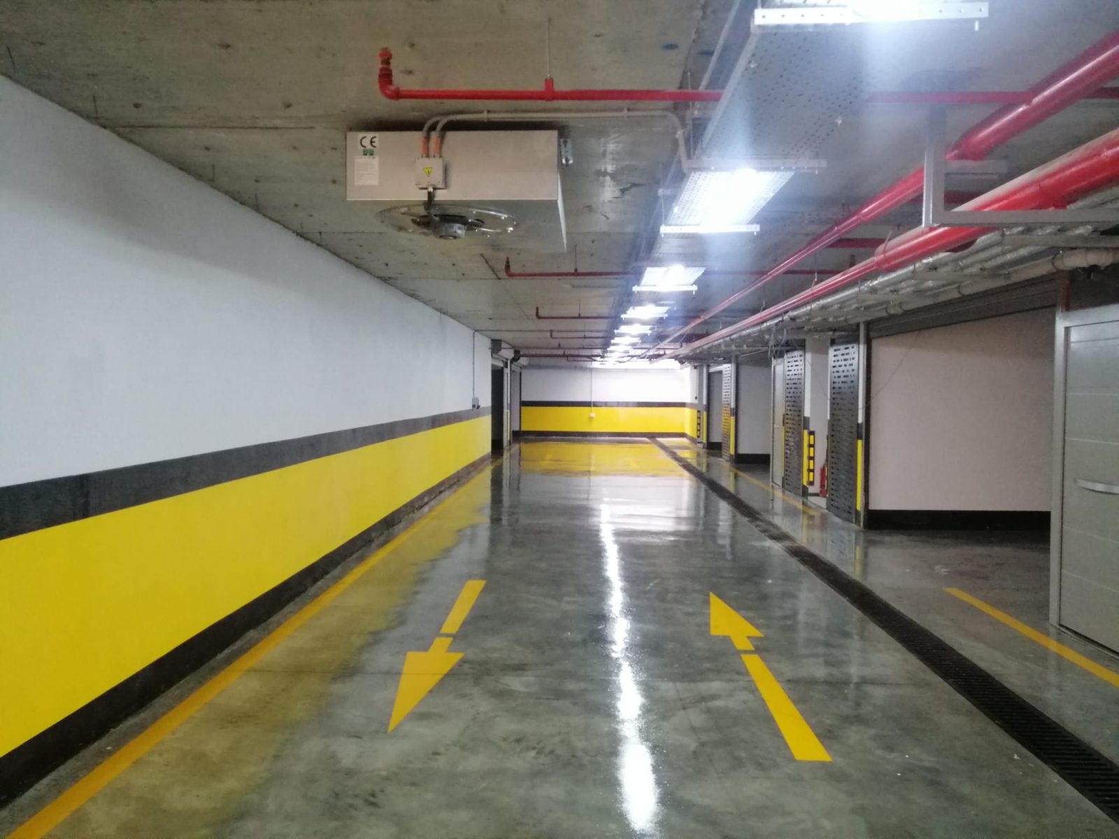 Kapalı otopark koridorunda cilalı zemin ve yön okları